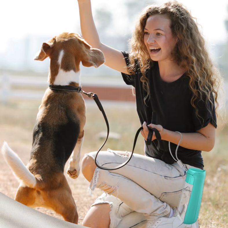 Femme souriante tenant une gourde pour chien dans son poignet