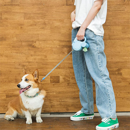 Corgi marche à côté de son maître avec laisse enrouleur